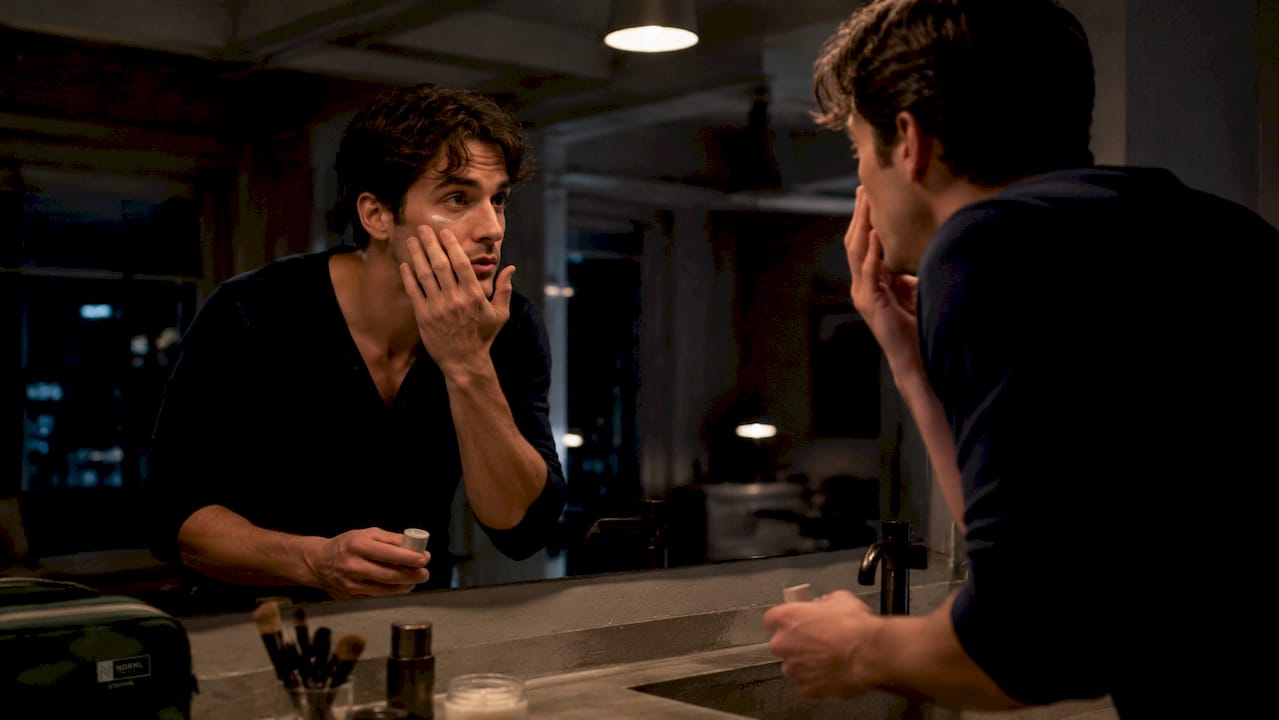 Man applying men's concealer at bathroom vanity