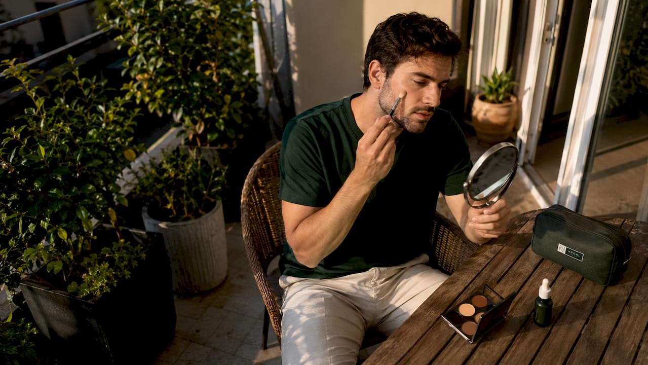 Man applying subtle undetectable makeup at home