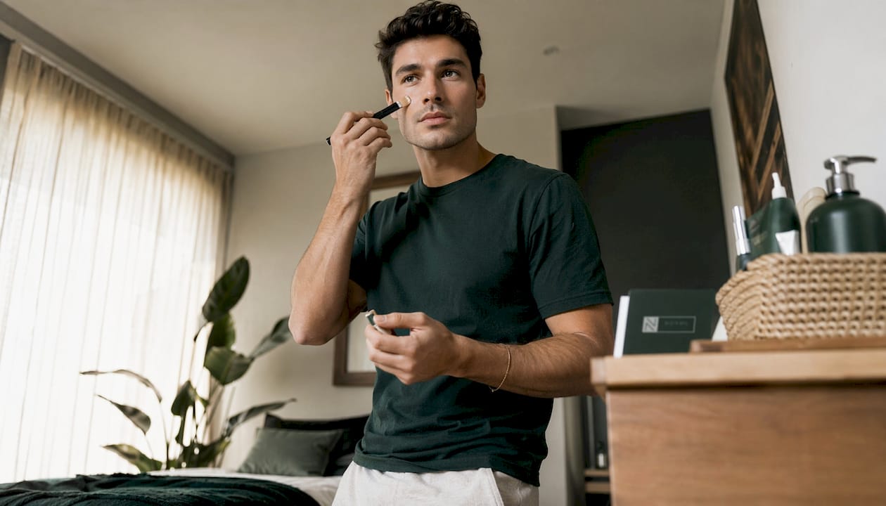 Man applying lightweight makeup in bathroom