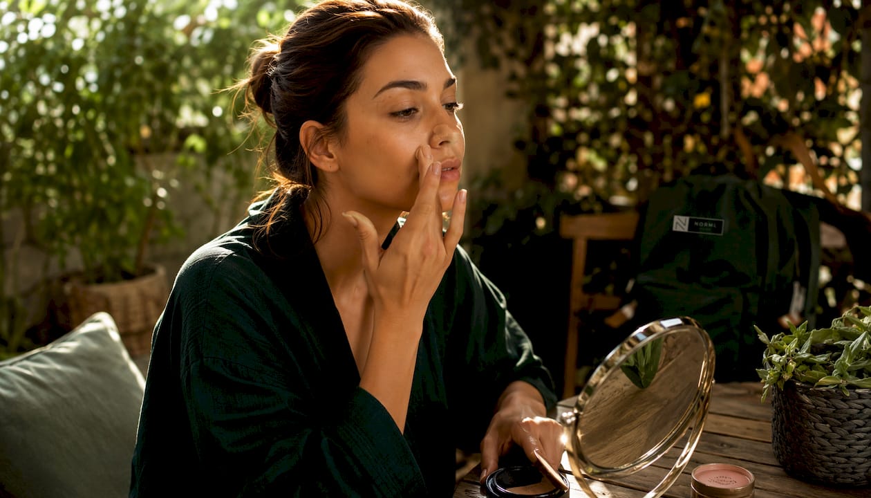 Woman applying natural undetectable makeup
